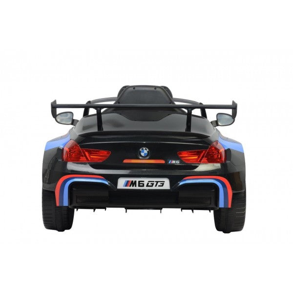 Black BMW M6 GT3 electric ride-on car for kids, 12 Volt, isolated on a white background.