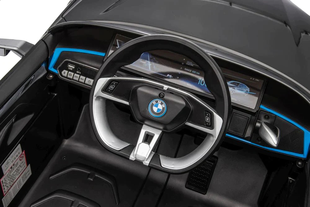 Interior view of a black BMW I4 children's ride-on car displaying steering wheel and digital dashboard