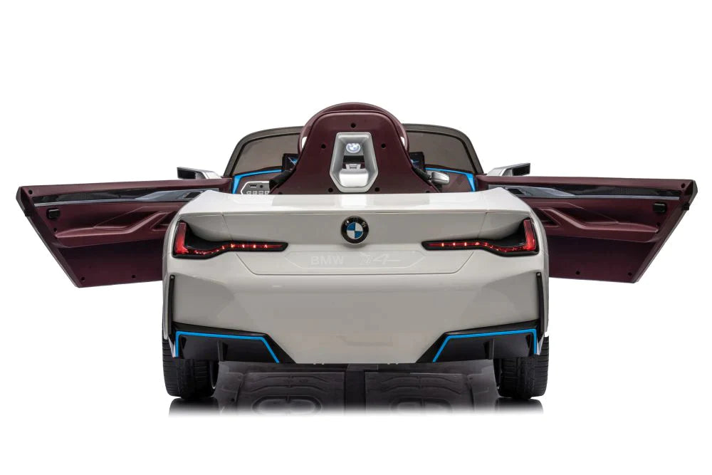 Rear view of a 12-volt white BMW I4 electric ride on car for kids, with upwards-opening doors ajar.