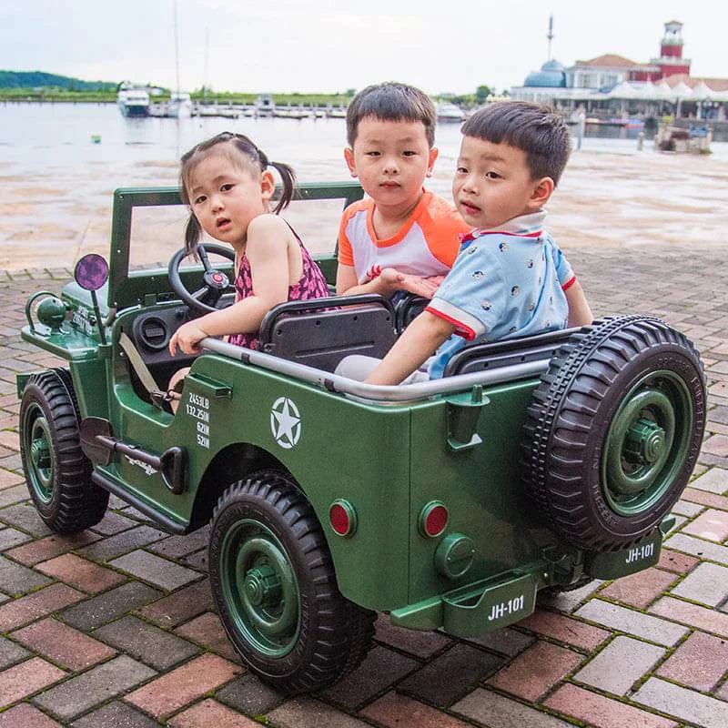 Three children enjoying a dark green, electric Willys-Jeep 4WD 3-seater kids ride on jeep outdoors.