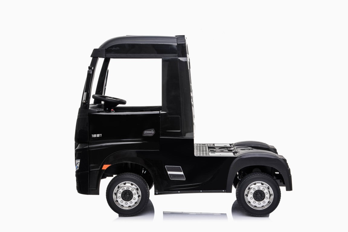 Side view of a black Actros electric ride-on semi-truck for kids on a white background.