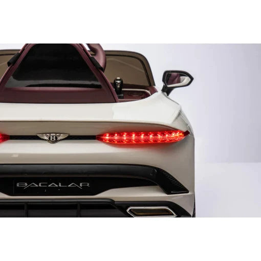 Rear angle of a white Bentley Bacalar electric ride on car highlighting its taillights and unique design features, equipped with parent remote.