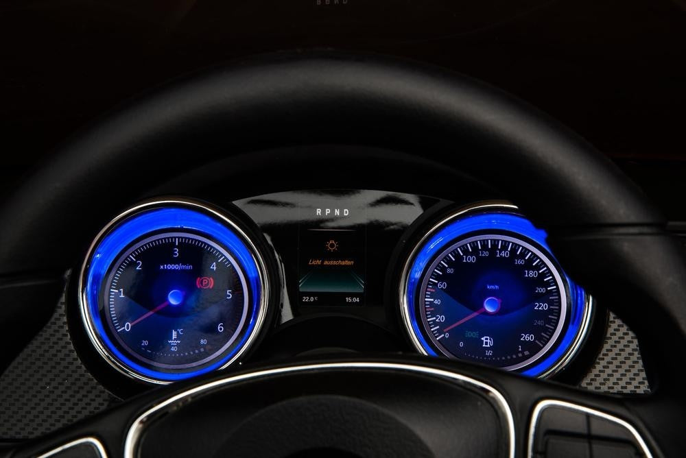Black Mercedes X-Class Pickup Electric Ride's illuminated dashboard showcasing speedometer, tachometer, and gear indicator at night