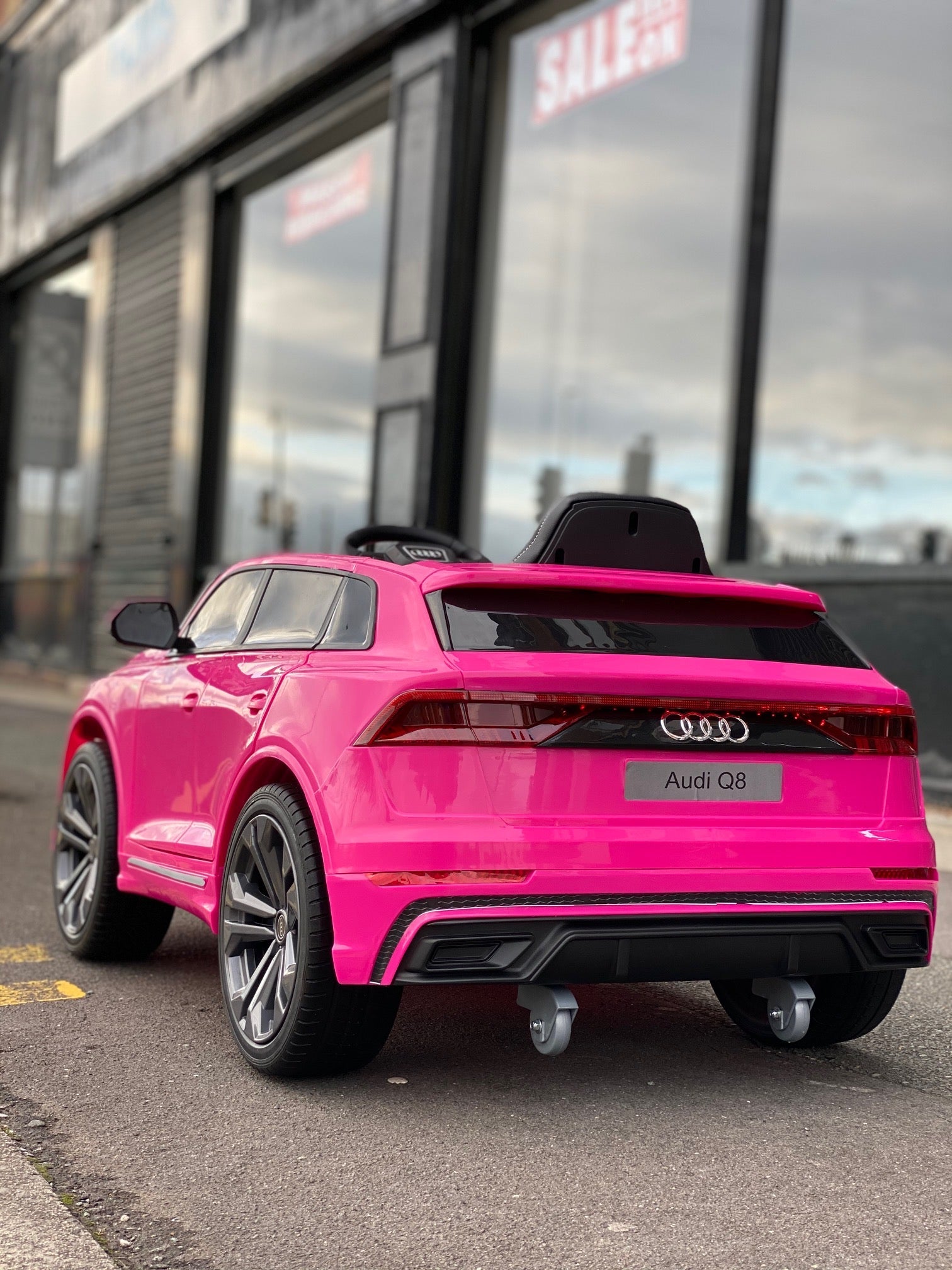 "Pink Audi Q8 SUV electric ride-on 12 volt car for kids parked outdoors"