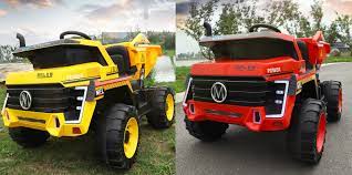 Two children's construction truck electric ride-ons, designed to resemble 4-wheel drive mining trucks, parked outdoors