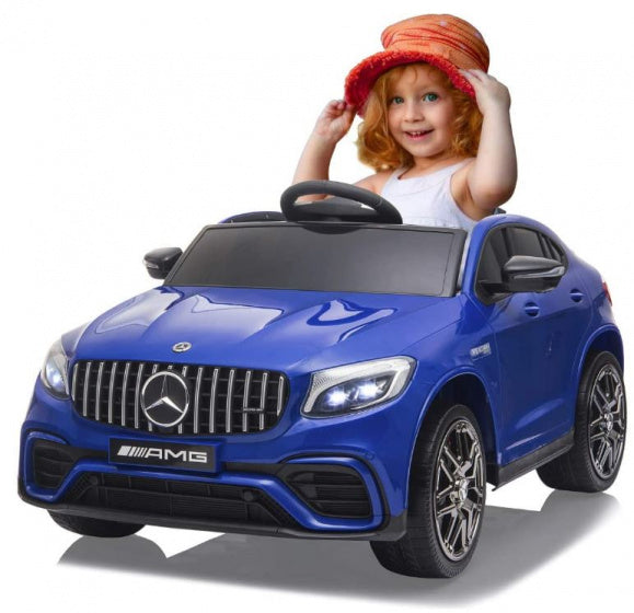 Young child in red hat behind blue Mercedes GLC 63S AMG electric ride on.