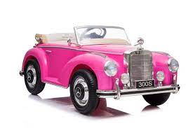 Bright pink 12V Battery Electric Mercedes-Benz 300S for kids, isolated on a white background