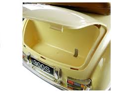 Open trunk of vintage Beige Mercedes Benz 300S children's electric ride on vehicle displaying ample storage.