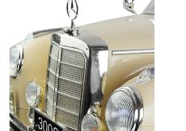 Close-up of beige Mercedes Benz 300S kid's electric ride-on car showing detailed front grille and headlights, officially licensed Mercedes replica.