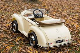 Beige Mercedes Benz 300S electric ride-on car for kids, replica design on autumn leaves background