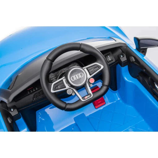 Close-up of blue Audi R8 toy car's steering wheel, dashboard and controls, part of children's electric ride-on collection