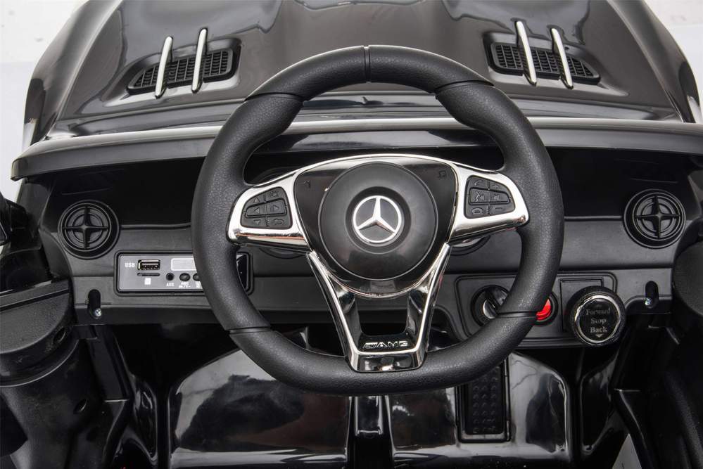 Interior view of a black Mercedes SL63 kids electric ride-on car highlighting the steering wheel and dashboard.