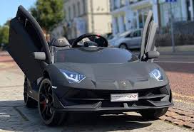 Matt Black LAMBORGHINI SVJ Kids Ride On, 12 Volt Electric Car with Upward-Opening Doors on city street